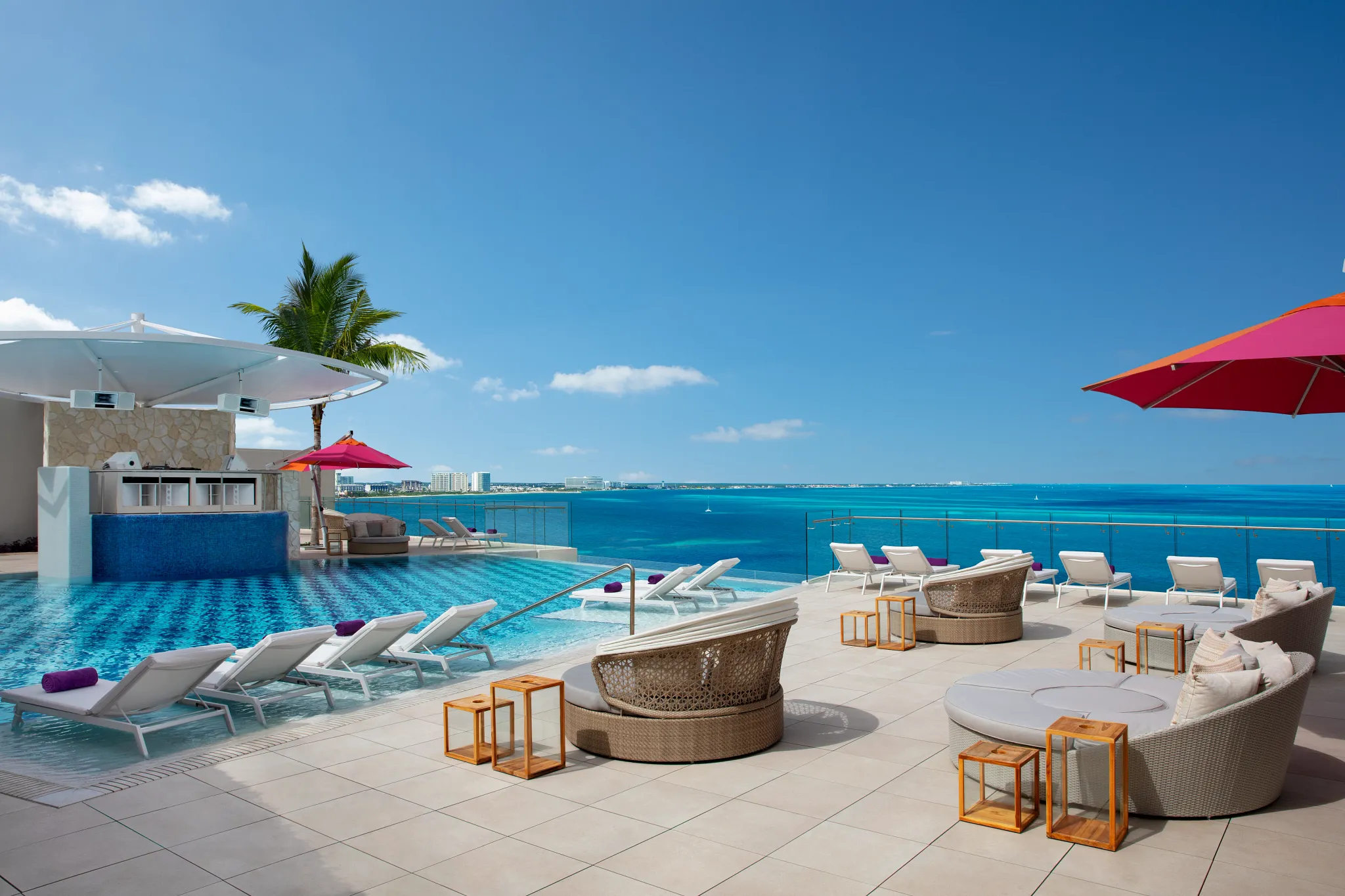 Wide daytime view of the Xcelerate Pool with ocean backdrop at Breathless Cancun Soul Resort.